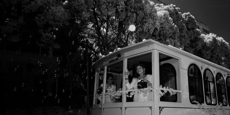 Black and white infrared photograph of a person blowing bubbles from a trolley in a parade 