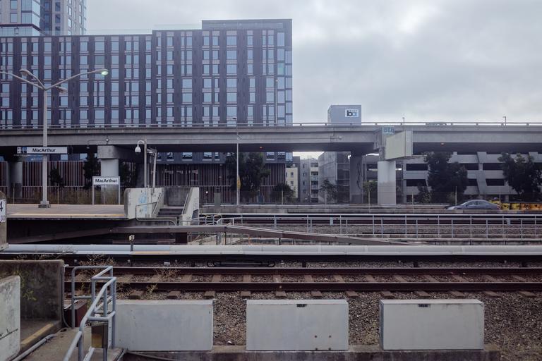 Photograph of buildings and freeway from train window